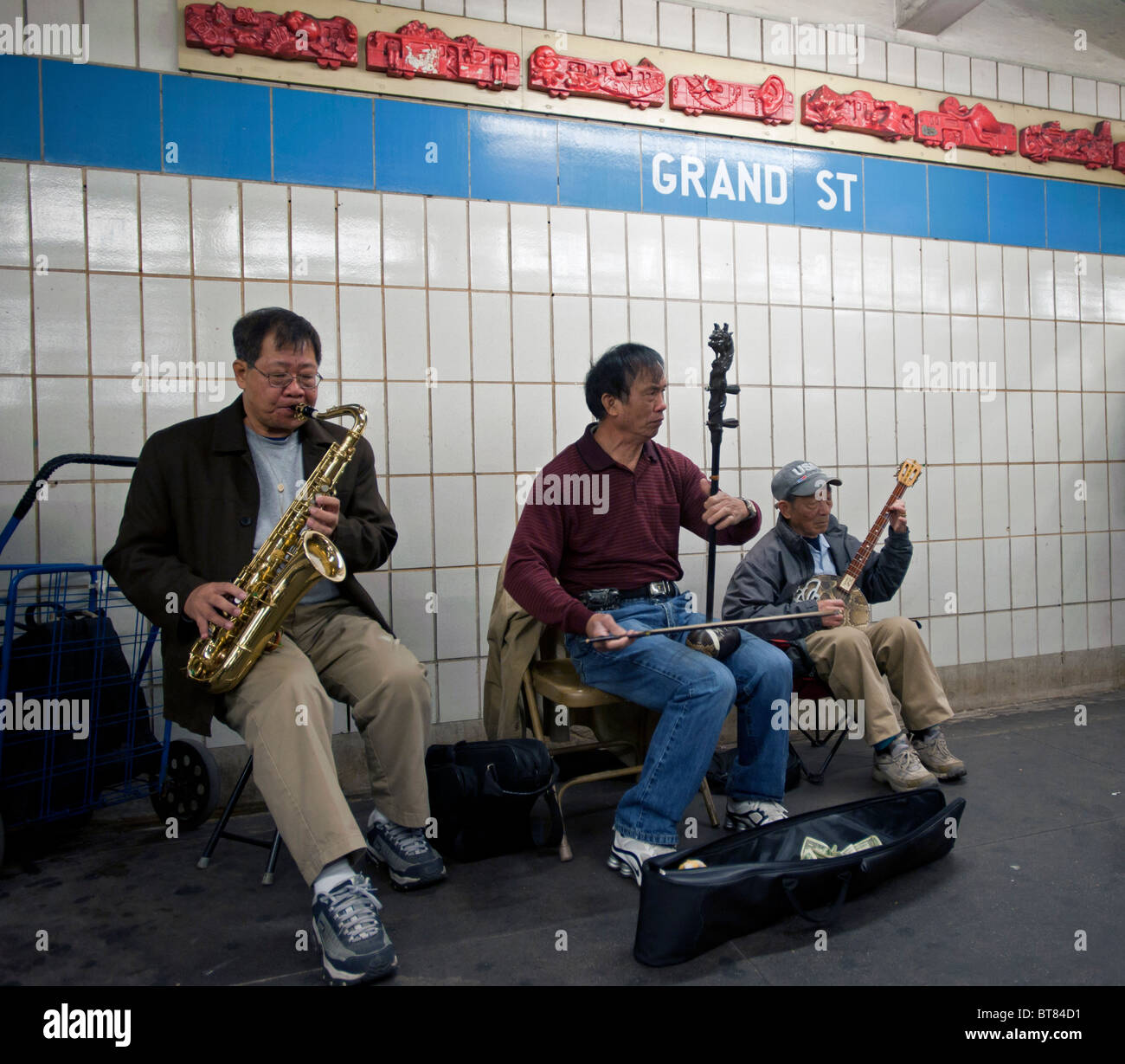 Chinesische alte Männer spielen traditionelle Musikinstrumente an Grand Street u-Bahnstation in Chinatown New York City USA Stockfoto