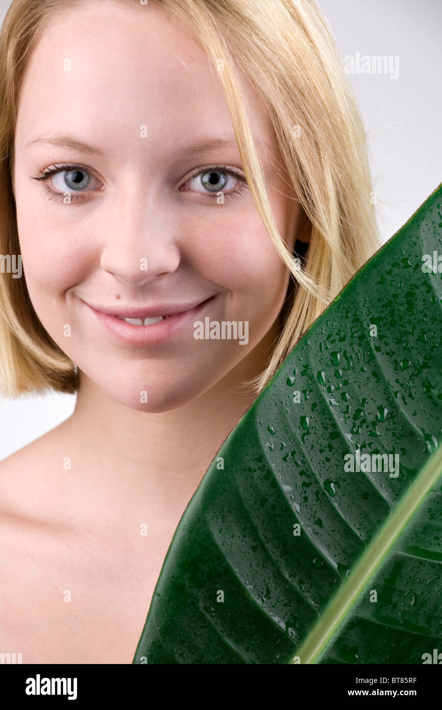 Junge Frau mit einem Blatt, Feuchtigkeit und empfindliche Haut Stockfoto