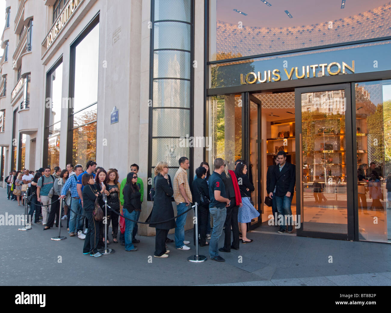 Warteschlange der Käufer außerhalb Louis Vuitton Store auf den Champs Elysees in Paris Frankreich Stockfoto