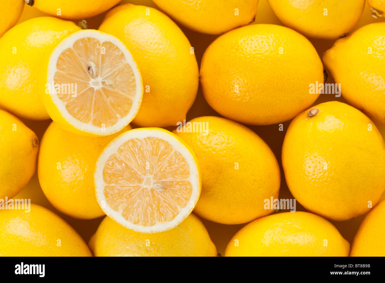 Zitronen-Hintergrund mit halbierten Früchten Stockfoto