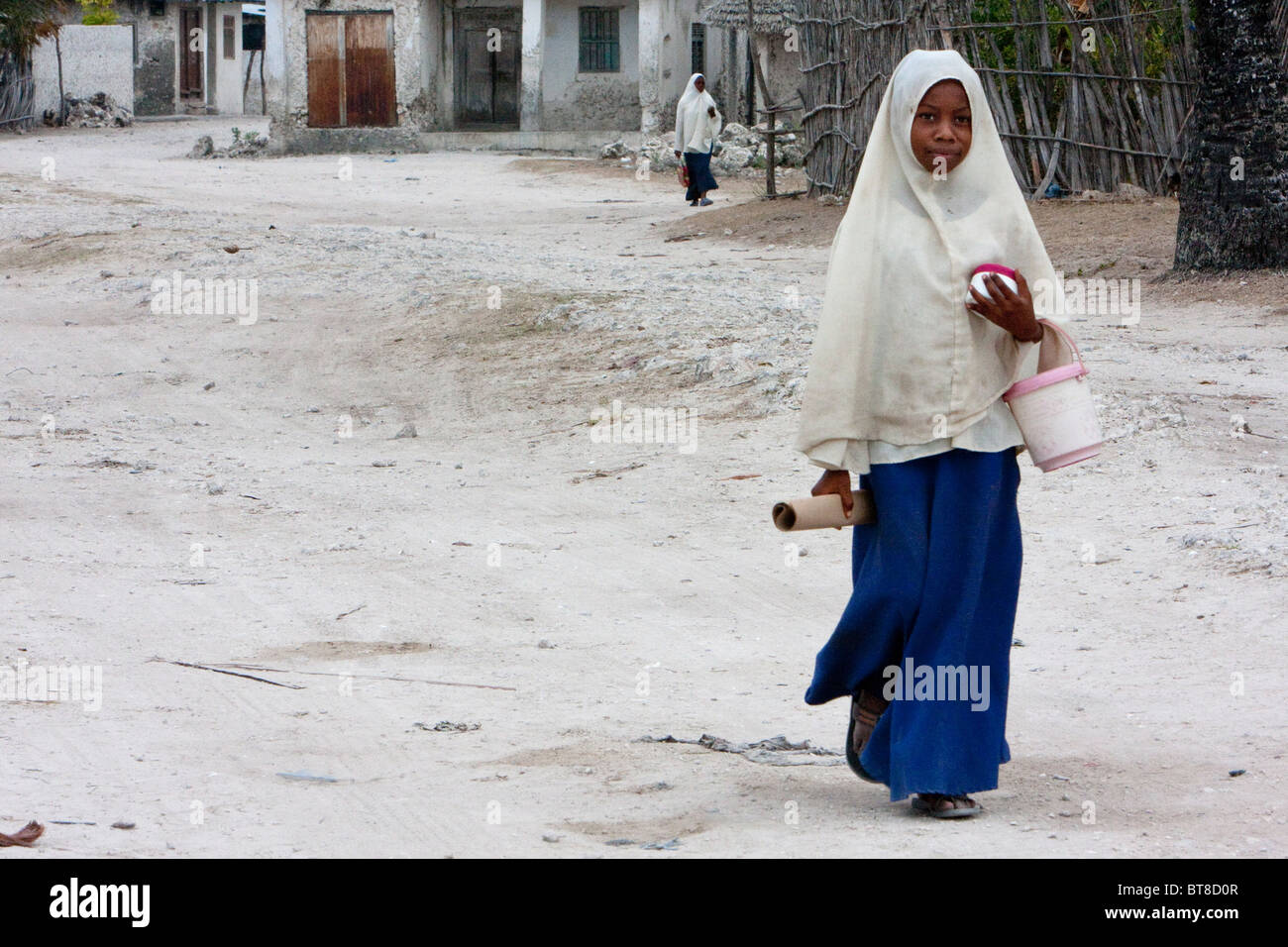 Jambiani, Sansibar, Tansania. Muslimische Schülerin zu Fuß zur Schule. Stockfoto