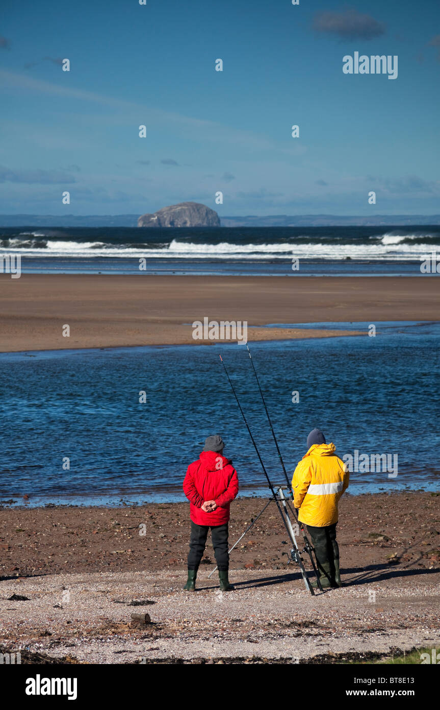 Zwei Männer in bunten Jacken Hochseeangeln Belhaven Strand, East Lothian Schottland, UK, Europa Stockfoto