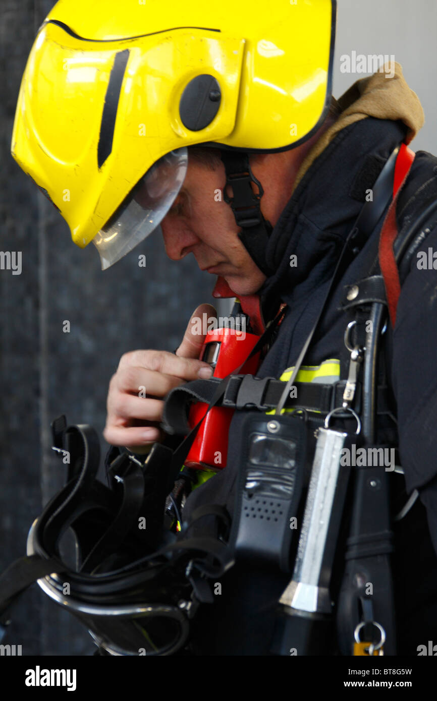 Feuerwehrmann Überprüfung seiner persönlichen radio Stockfoto