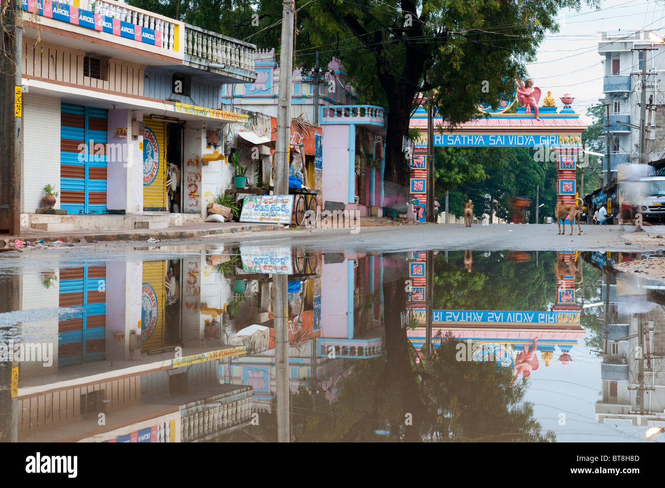 Reflexionen in einer überfluteten Straße am Eingang von der indischen Stadt Puttaparthi Stockfoto