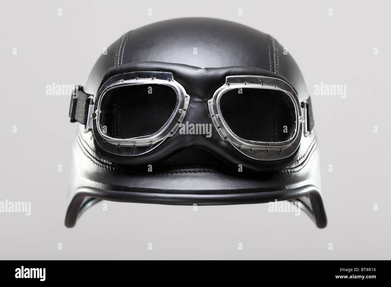 Renaissance-Antiqua uns Armee-Motorrad-Helm mit Brille, auf grauem Hintergrund Stockfoto