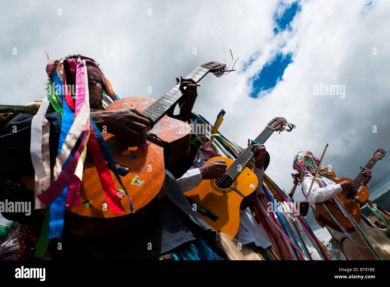 Männer, tragen bunte Kostüme, spielen Gitarren während des Inti Raymi Fest in der Provinz Pichincha, Ecuador. Stockfoto
