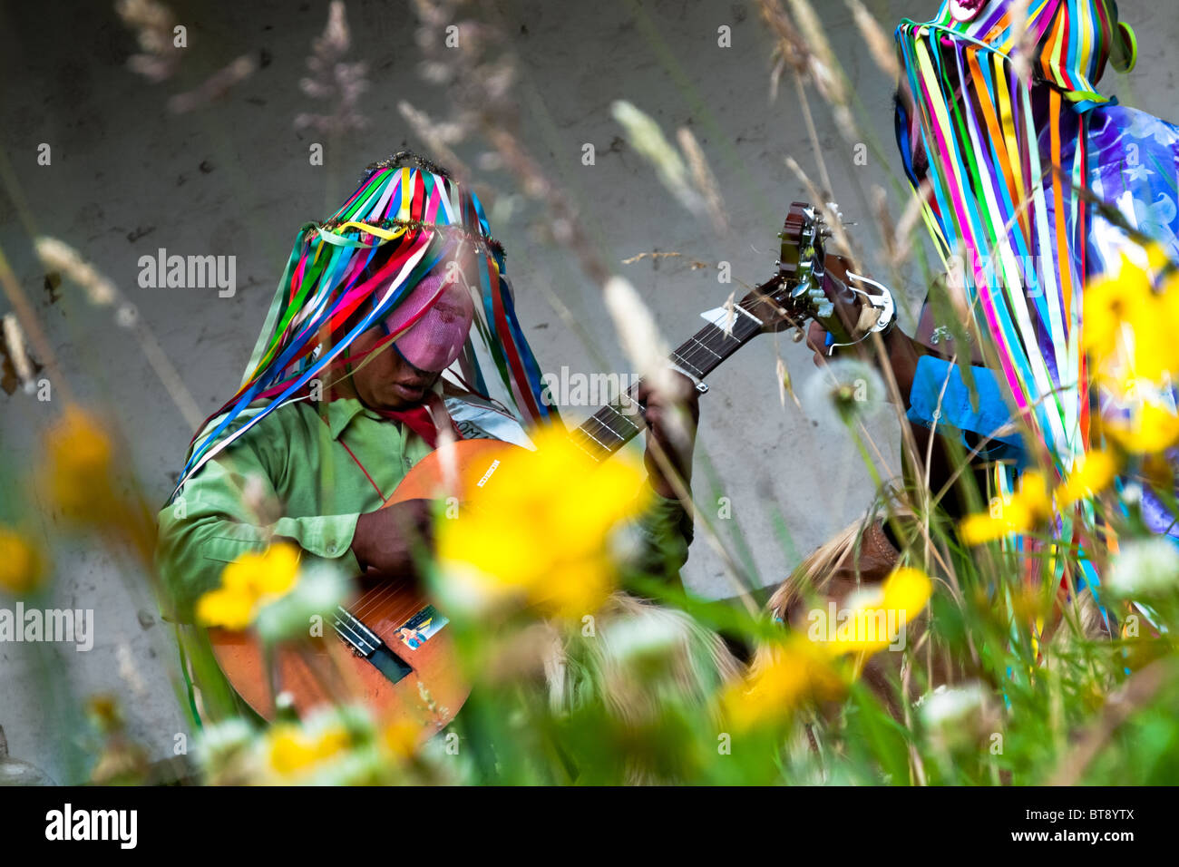 Männer in bunten Kostümen, spielen Gitarre während das Inti Raymi fest in der Provinz Pichincha, Ecuador. Stockfoto