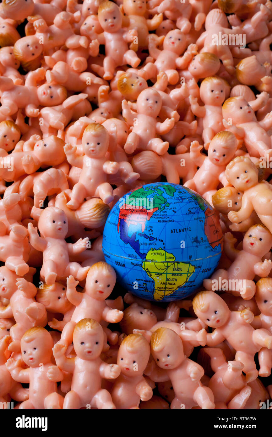 Kleine Spielzeug Babys und Globus, über Bevölkerung Stockfoto