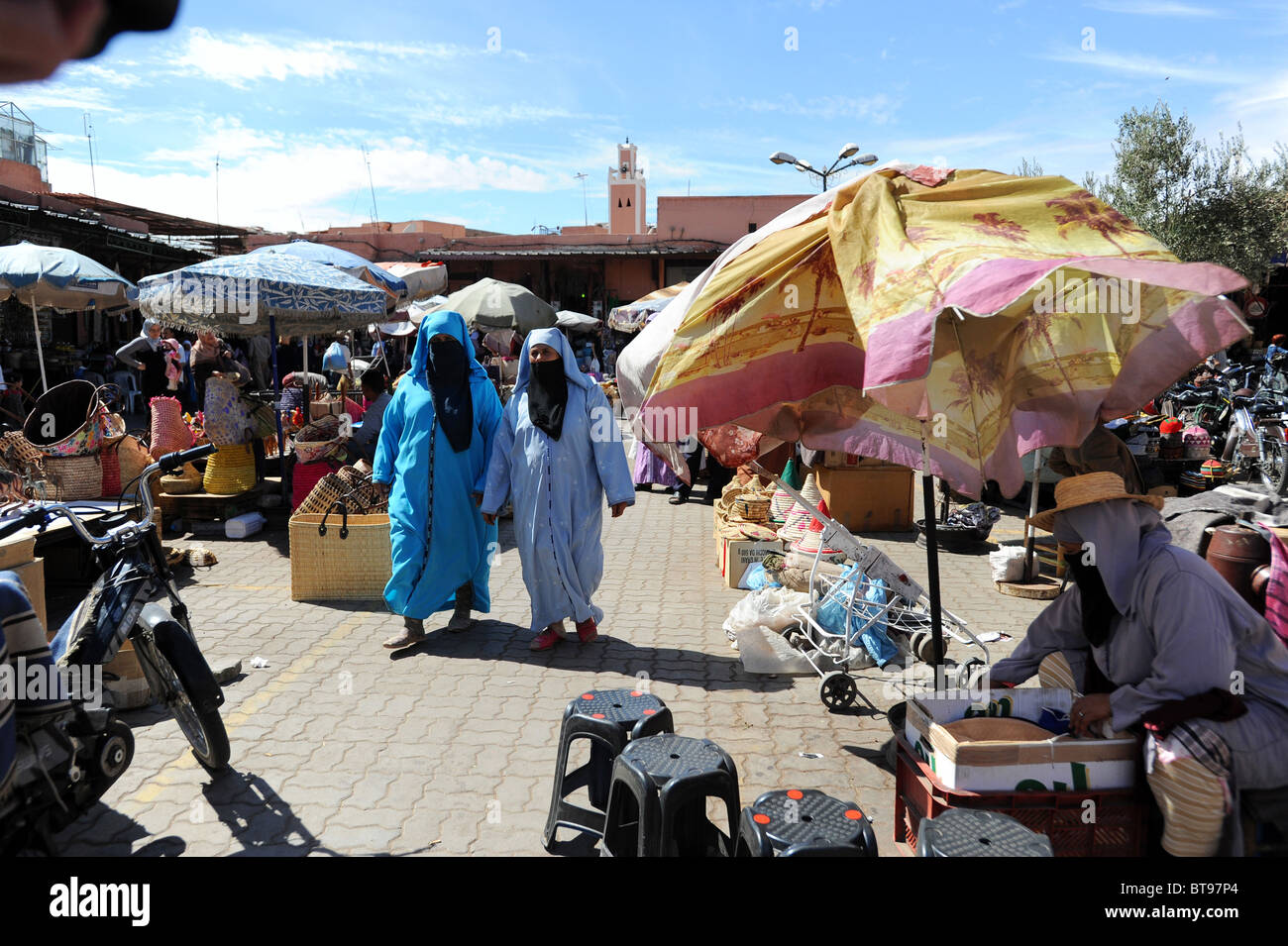Islamische Frauen in traditioneller Kleidung Marktplatz Djemaa El Fna, Marrakesch durchschreiten. Stockfoto