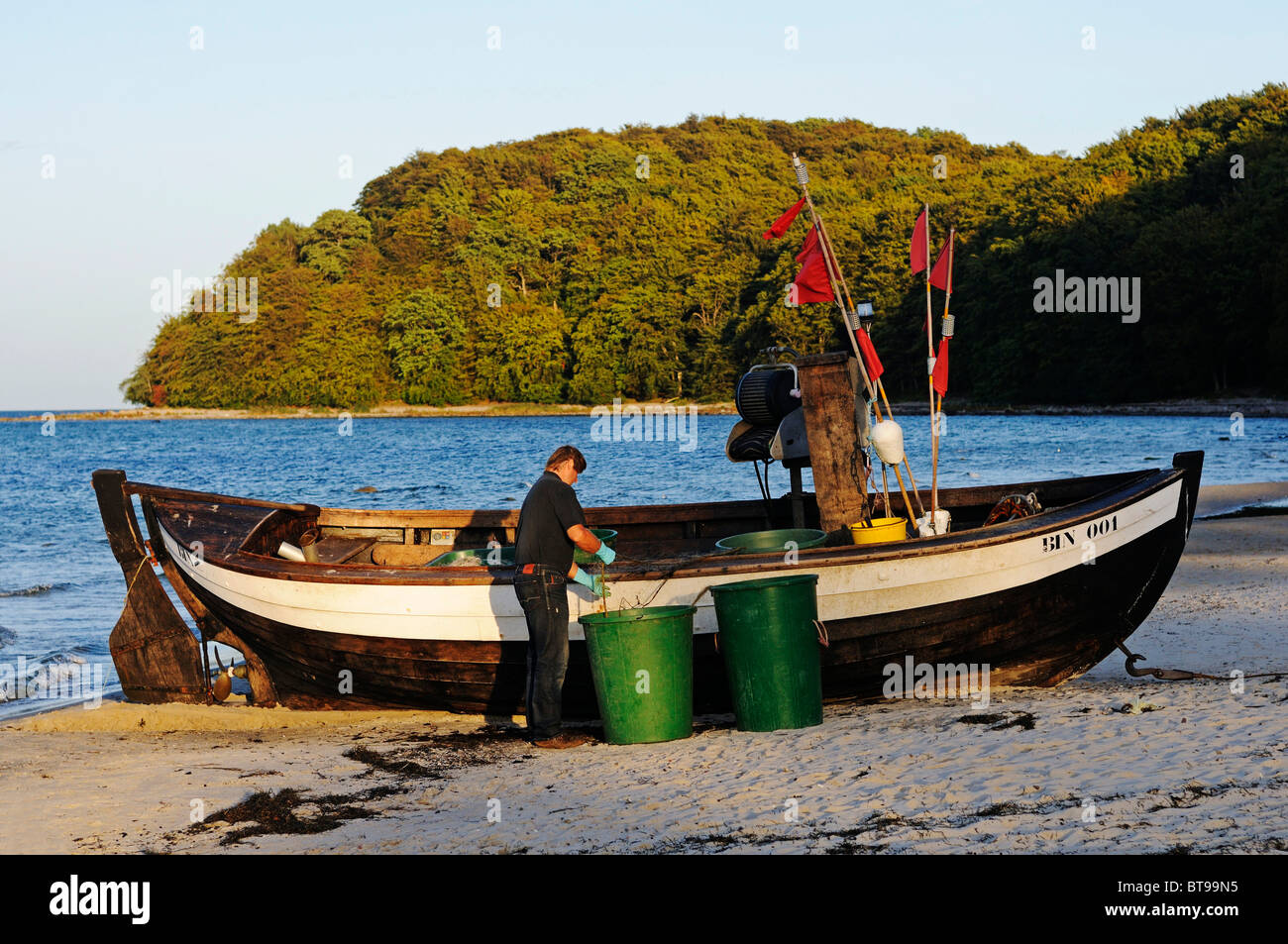 Fischer, die Reinigung seiner Netze im Abendlicht, Ostsee resort Binz, Insel Rügen, Mecklenburg-Vorpommern Stockfoto