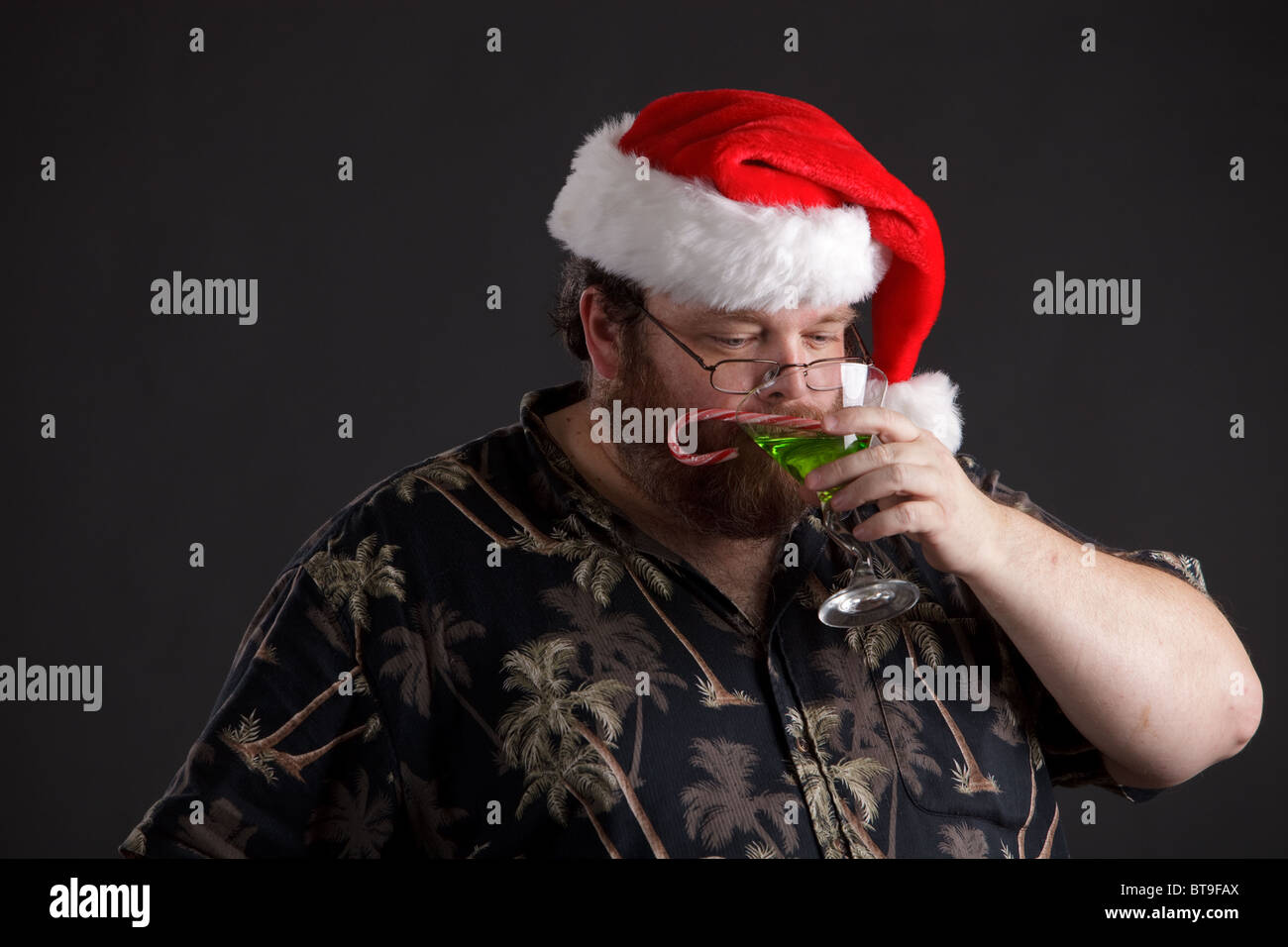 Eine übergewichtige Mann in Santa Hut und Tropical Hemd Stockfoto