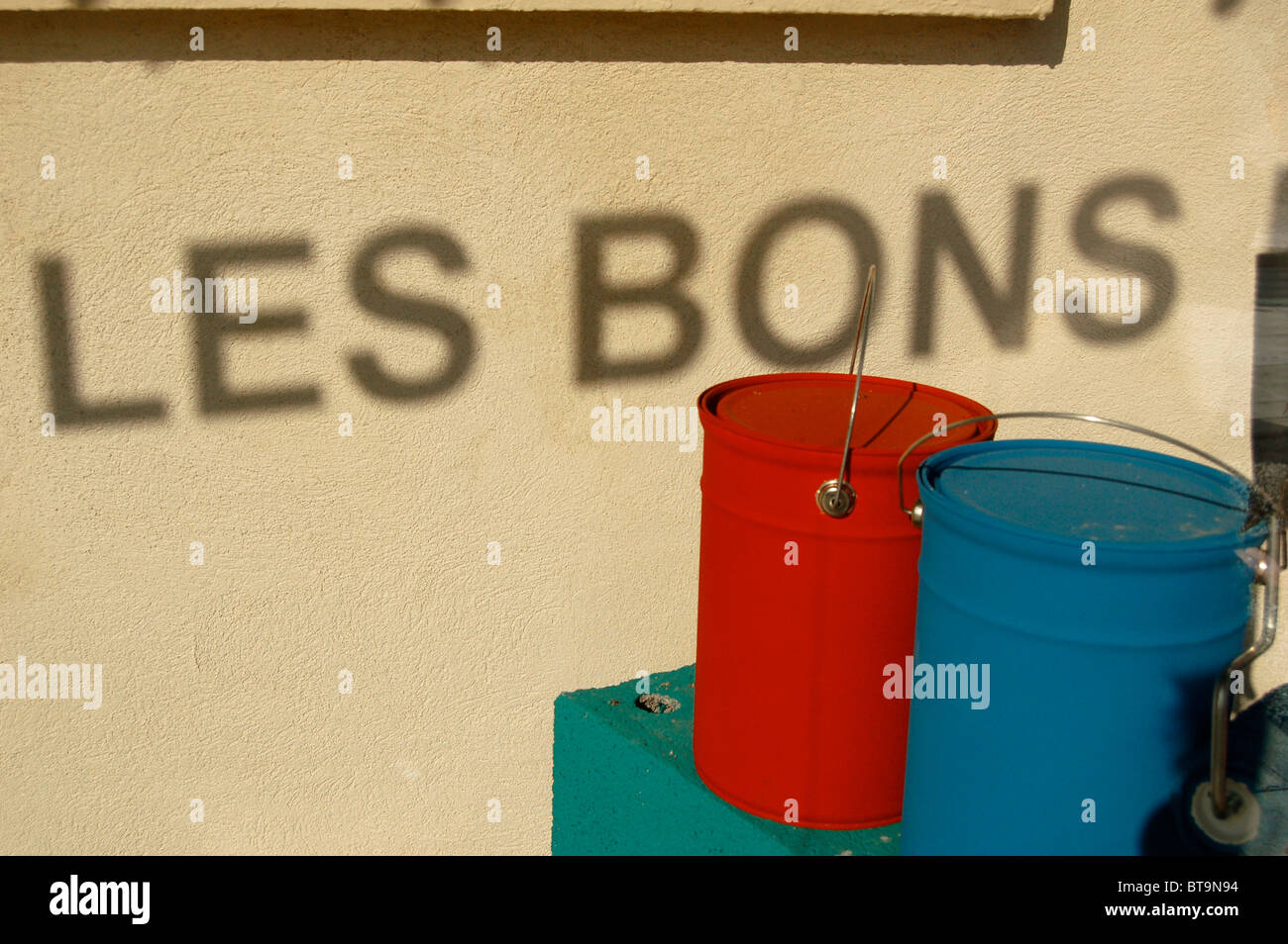"Les Bons" Stimmen im Schatten im Schaufenster, mit roten und blauen Schmerzen Dosen, Nizza, Frankreich Stockfoto