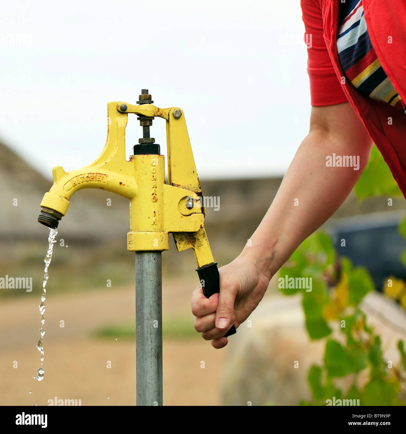 Nahaufnahme von Frau Pumpen von Wasser aus einem Brunnen. Stockfoto