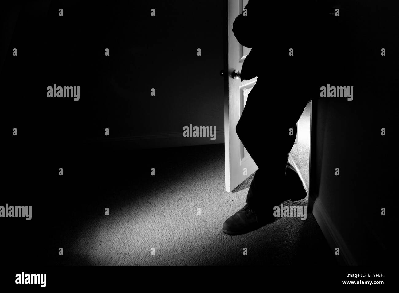 Mann an der Wand eines dunklen Raumes gelehnt Stockfoto