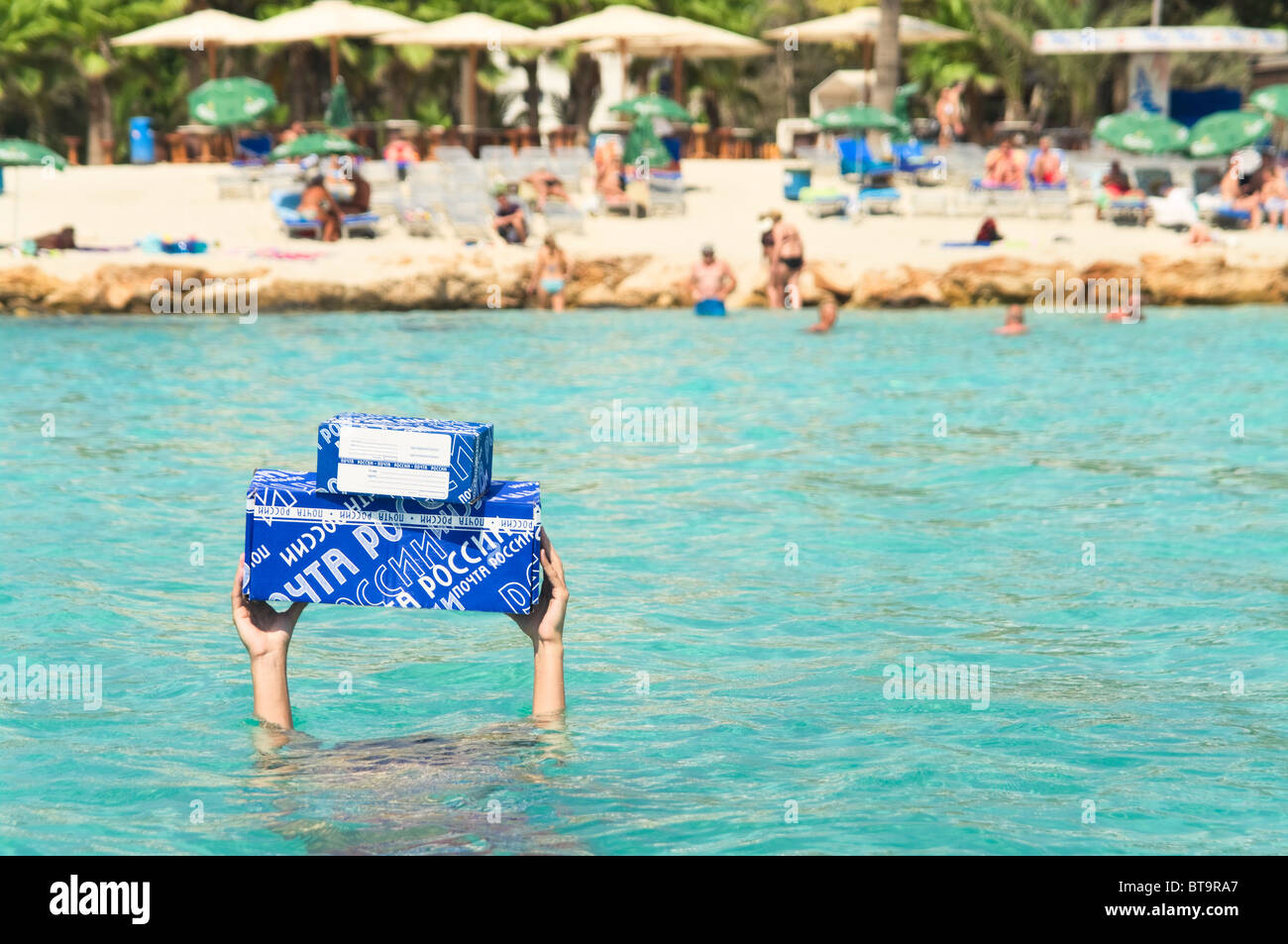 Blaue Briefkästen Russlands in den Händen eines Mannes ertrinken im Meer. Mann unter Wasser, Pakete auf ausgestreckten Armen Stockfoto