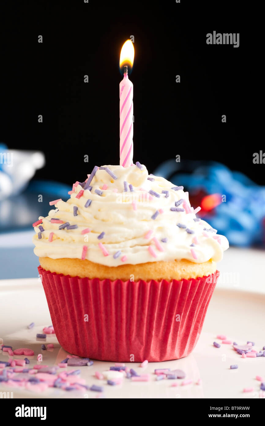 Cupcake mit Glasur und Streuseln garniert mit einer Kerze Geburtstag. Stockfoto
