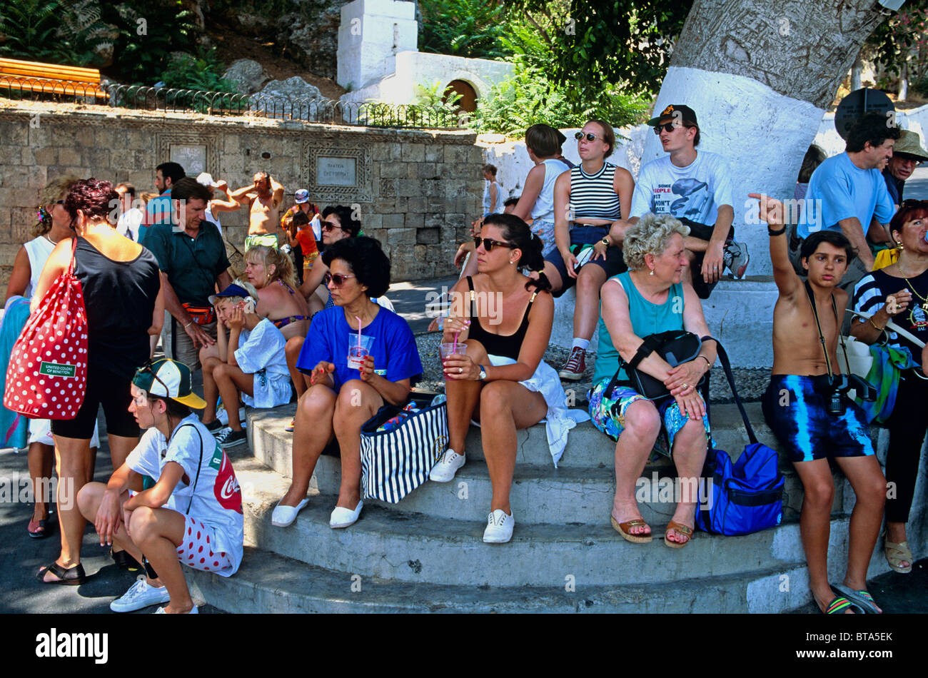 Touristen warten auf einen Bus In der Square Lindos Rhodos griechische Inseln Griechenland Hellas Stockfoto