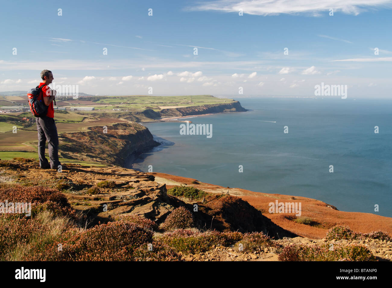 Männliche Wanderer mit Blick auf alte Alaun Steinbrüche zwischen Skinningrove und Staithes auf The Cleveland Art National trail Stockfoto