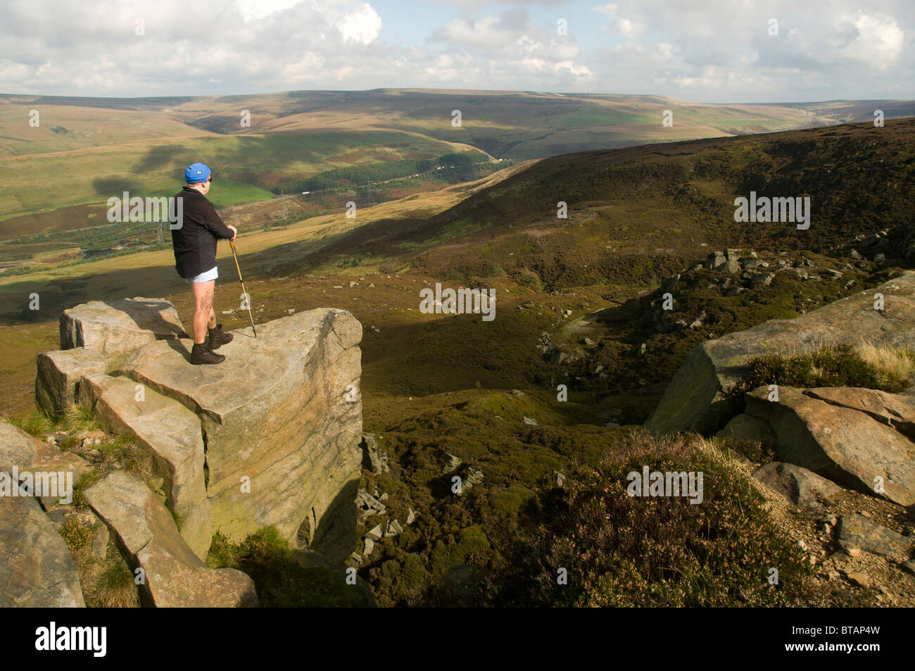 Ein Walker auf Dowstone Felsen, Bleaklow Fell, über Woodhead Reservoir, Longdendale, Peak District, Derbyshire, England, UK Stockfoto