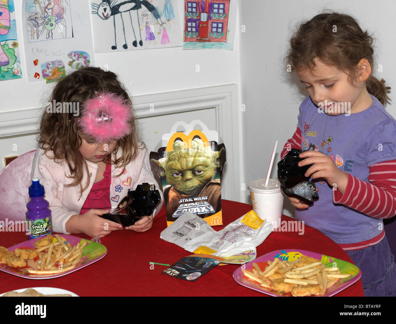 Schwestern mit einem McDonalds Happy Meal mit Star Wars Spielzeug England spielen Stockfoto