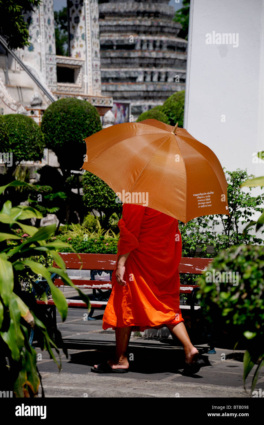 Wat Arun Tempel der Morgenröte Bangkok Thailand Mönch mit orange Gewand und Sonnenschirm Stockfoto
