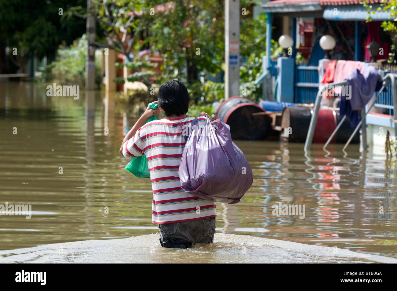 Mann, watet in einer überfluteten Dorfstraße in Nakhon Ratchasima in Thailand während der Flut im Oktober 2010 Stockfoto