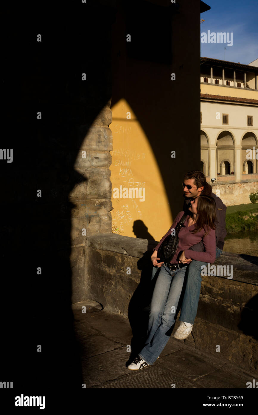 Italienische Liebhaber kuscheln auf der zentralen Spannweite von Ponte Vecchio in Florenz. Stockfoto