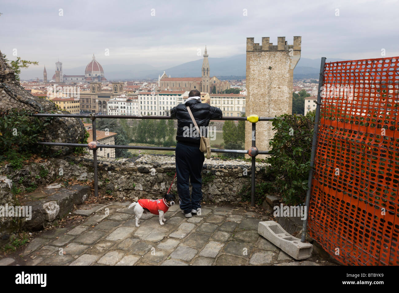 Hund und Besitzer Pause in der Nähe von Bau-Netting beim Spaziergang in der Nähe von Piazza Michelangelo Florenz Skyline anzeigen Stockfoto