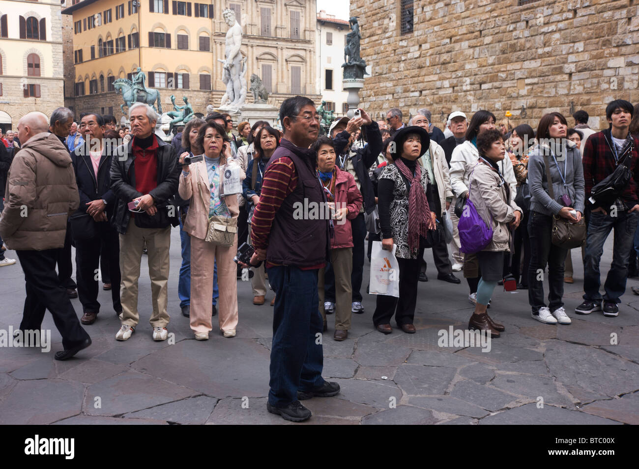 Eine asiatische Reisegruppe bewundert Renaissance Statuen in Piazza della Signoria in Florenz. Stockfoto