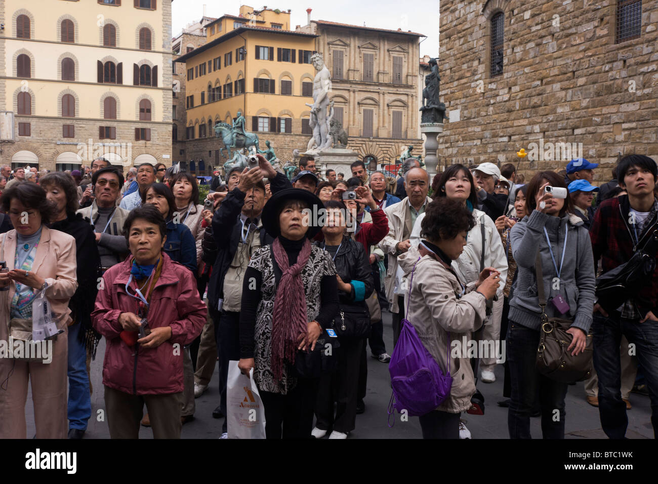 Eine asiatische Reisegruppe bewundert Renaissance Statuen in Piazza della Signoria in Florenz. Stockfoto