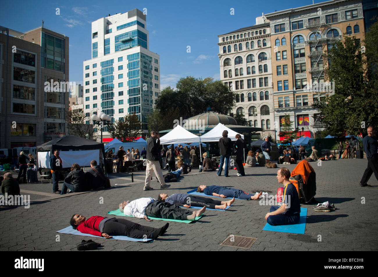 Yoga-Praktizierende aller Niveaus zu beteiligen, in einen kostenlosen Yoga-Kurs in Union Square Park in New York gegeben Stockfoto