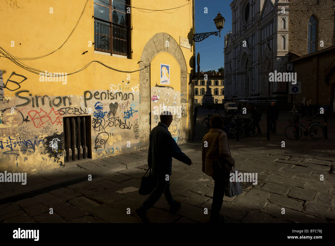 Einheimischen vorbei an Graffiti Straßenecke und touristischen Kiosk in der Nähe von Piazza Santa Croce in Florenz. Stockfoto