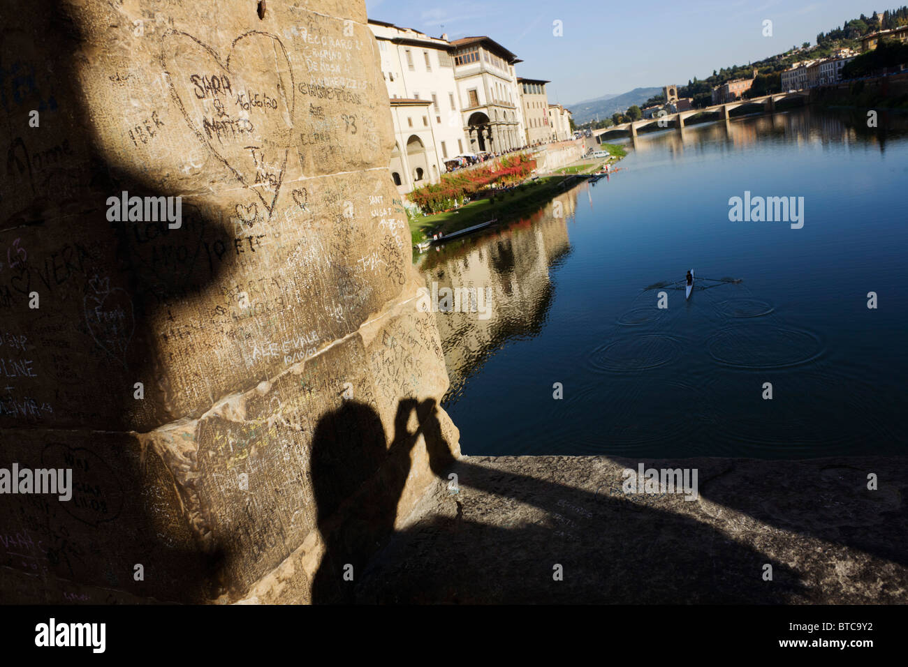 Schatten des touristischen und Säule Graffiti auf Ponte Vecchio, der Fluss Arno überquert. Stockfoto