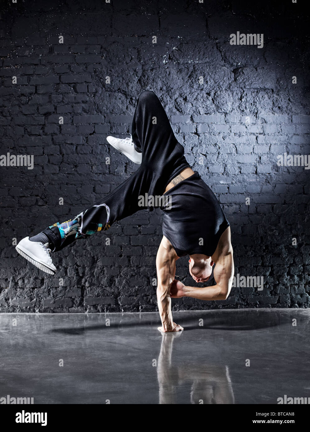 Starken Jüngling Breakdance. Auf dunklen Wand Hintergrund. Stockfoto