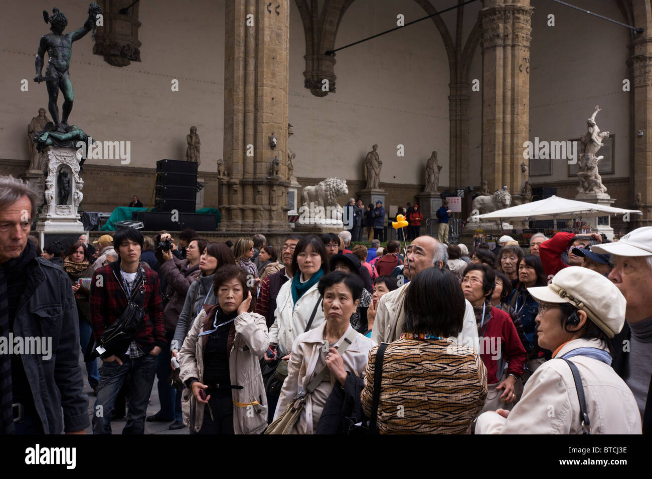 Eine asiatische Reisegruppe bewundert Renaissance Statuen in Florenz die Loggia dei Lanzi, Piazza della Signoria. Stockfoto