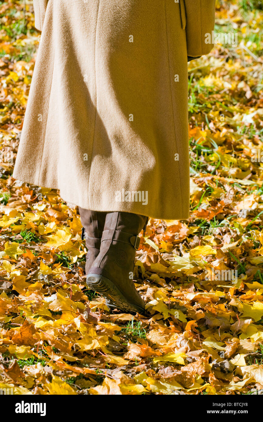 UNTEREN BEREICH DER FRAU ZU FUß AUF HERBST BLÄTTER IM WINTER ALLEIN. Stockfoto