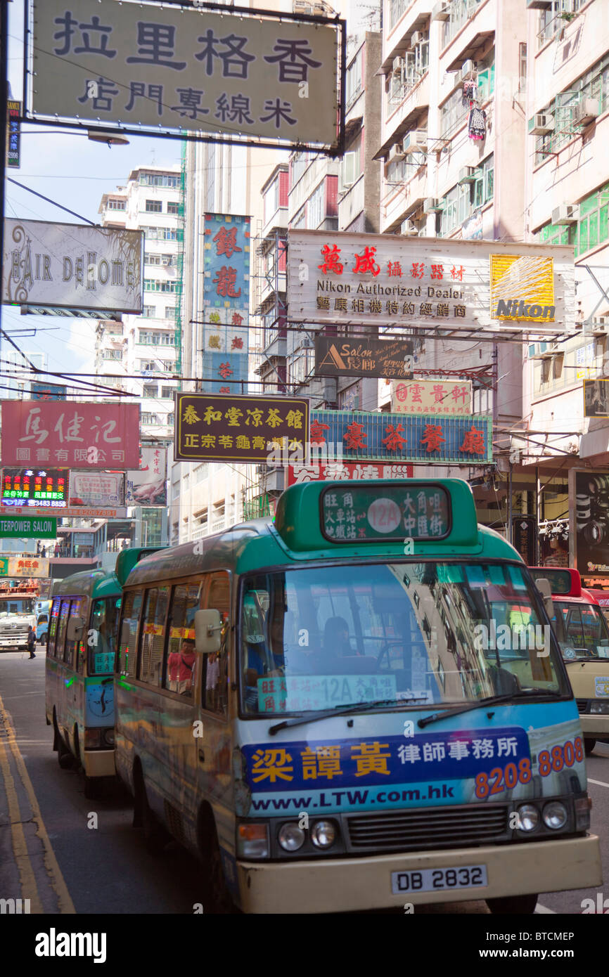 Leichte Linienbus in Kowloon, Hong Kong inmitten der bunten Straßenschilder Stockfoto