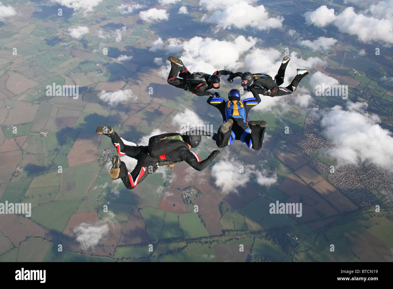 Vier Fallschirmspringer im freien Fall hoch in die Luft Stockfoto
