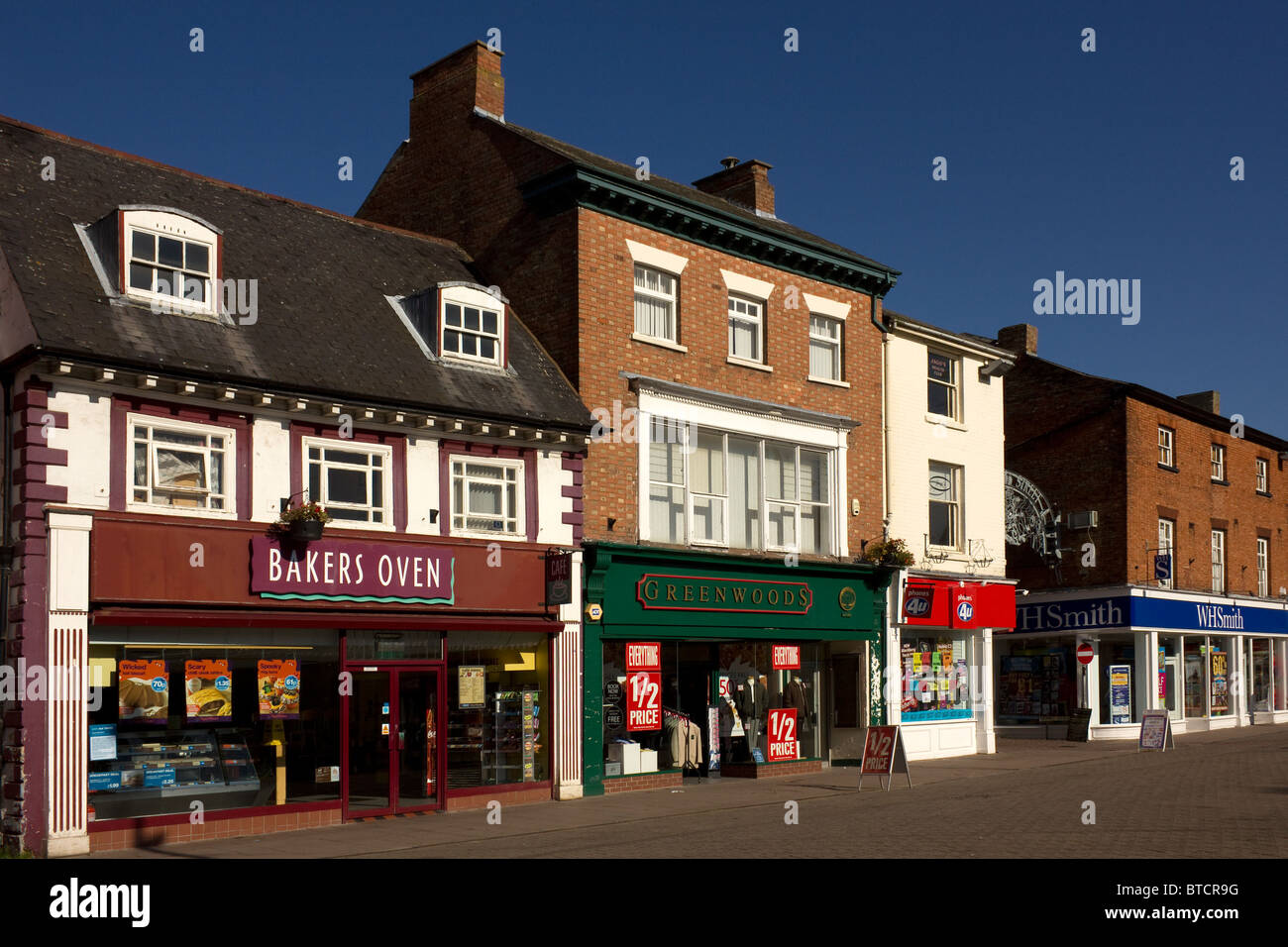 Sonnigen Stadtzentrum Ladenfronten auf einem ruhigen Sonntagmorgen, Marktplatz, Melton Mowbray, Leicestershire, England, UK Stockfoto
