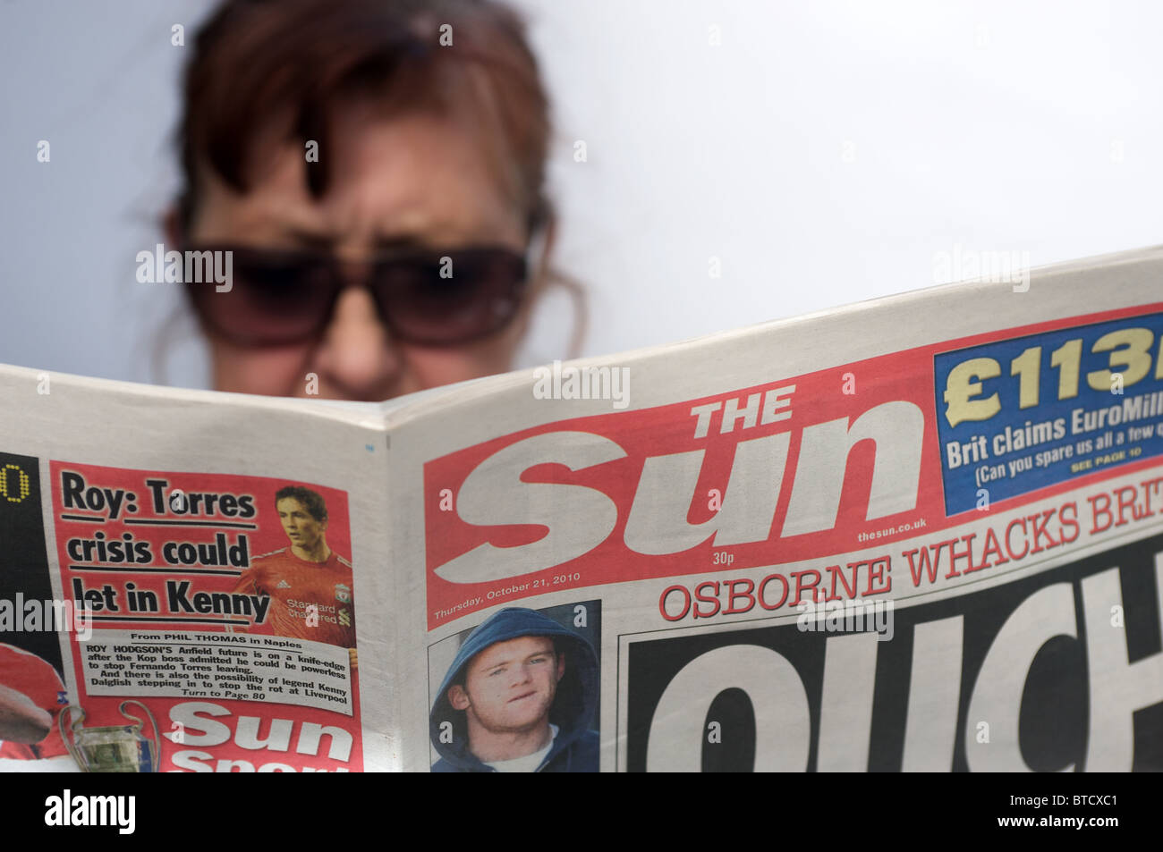 Frau bereit, eine Kopie der Zeitung the Sun Stockfoto