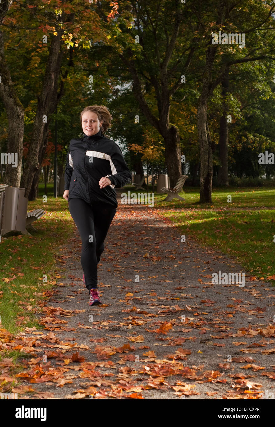 Schönen weiblichen Athleten laufen im Park an einem schönen Herbsttag. Stockfoto