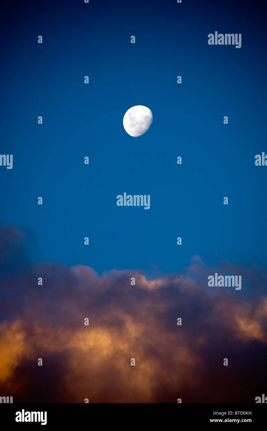 Fast volle helle Mondaufgang weiße über das letzte Licht in den Wolken Stockfoto