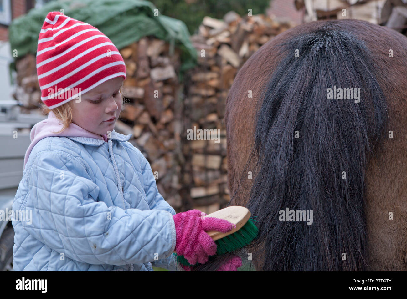 Porträt eines Mädchens einen Pferdes Schweif Bürsten Stockfoto