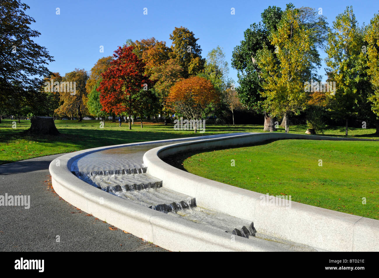 Prinzessin Diana Gedenkbrunnen im Hyde Park London England UK bilden eine kreisförmige Künstliche rill Wasserspiel mit Herbstfarben auf Bäumen Stockfoto