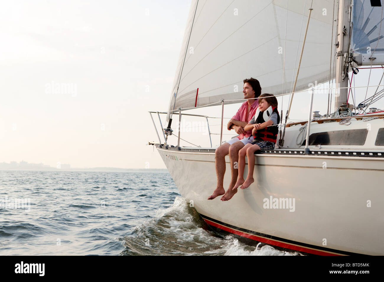 Vater und Sohn sitzen auf yacht Stockfoto