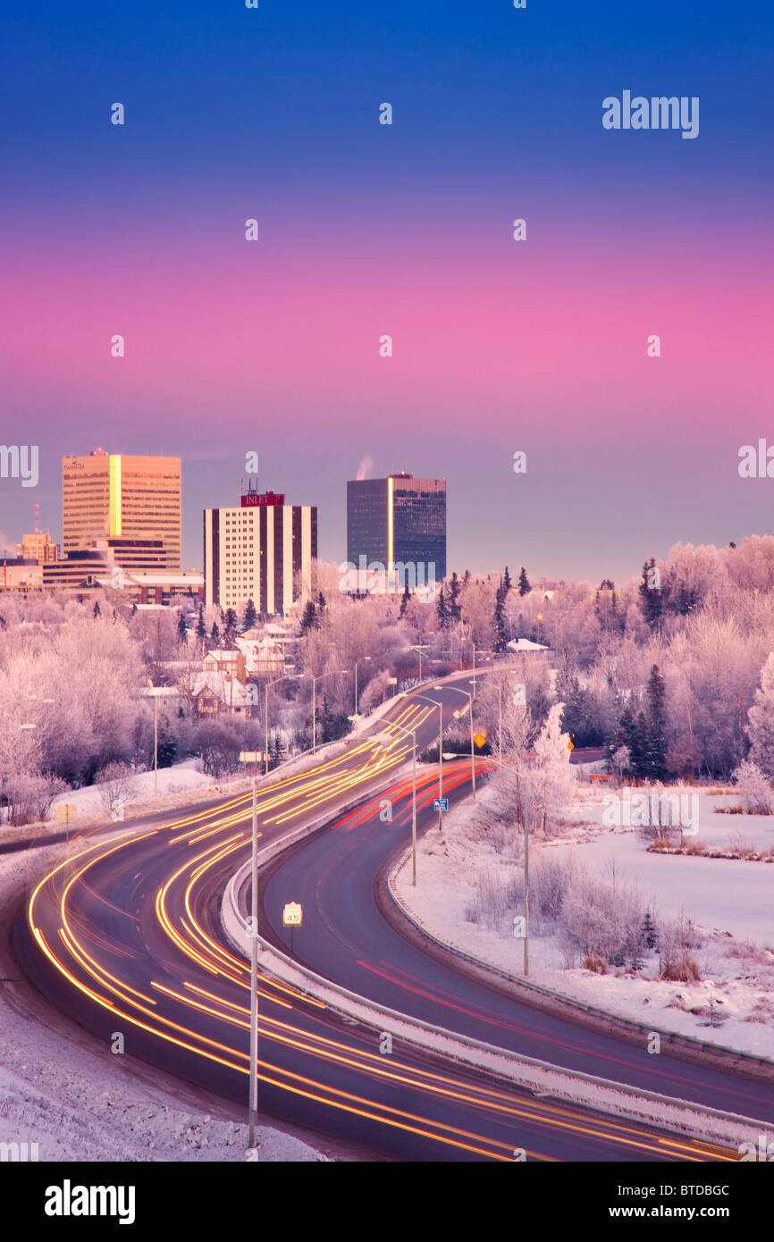 Blick auf den Sonnenuntergang des Verkehrs auf Minnesota Blvd. mit Downtown Anchorage im Hintergrund, Yunan Alaska Winter/n Stockfoto