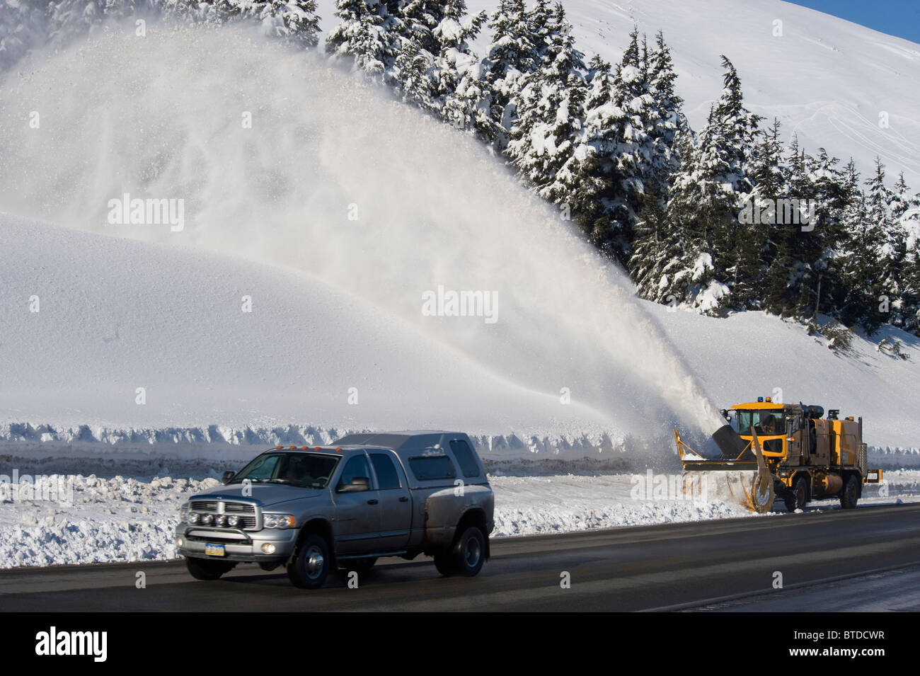 Eine Schneefräse folgt einen LKW auf der Autobahn in Turnagain Pass, Kenai-Halbinsel, Yunan Alaska, Winter Stockfoto