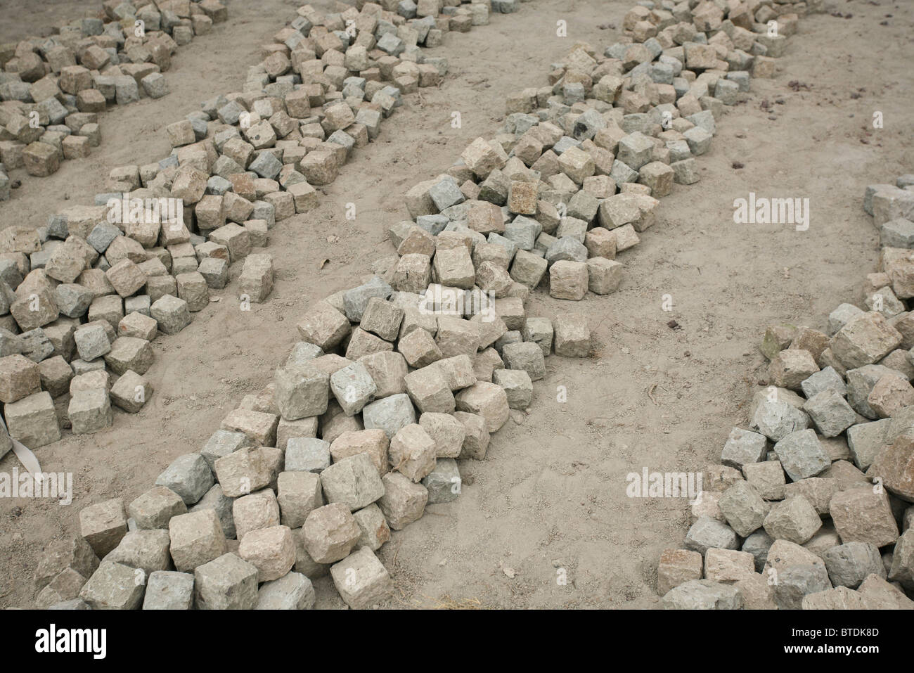 Handgeformten quadratische Kopfsteinpflaster Stein Fertiger in Reihen bereit gelegt werden Stockfoto
