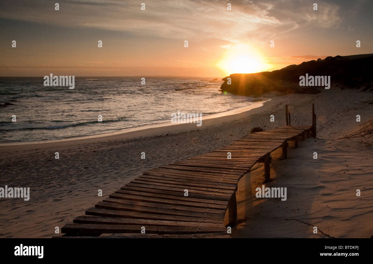 Sonnenuntergang über dem Strand mit Holzsteg Stockfoto