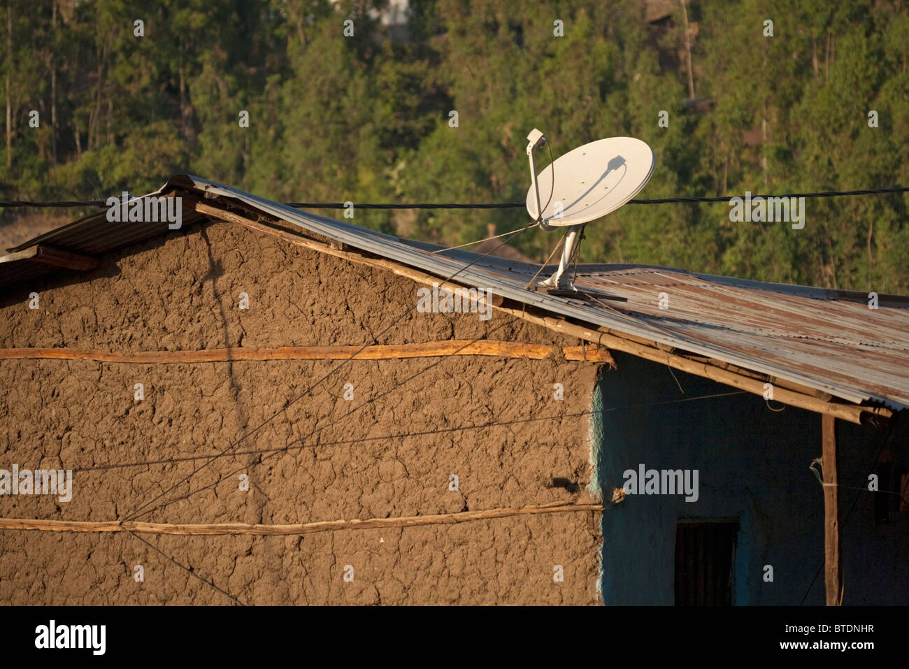 Satellitenschüssel auf dem Wellblech-Dach einer Hütte Stockfoto